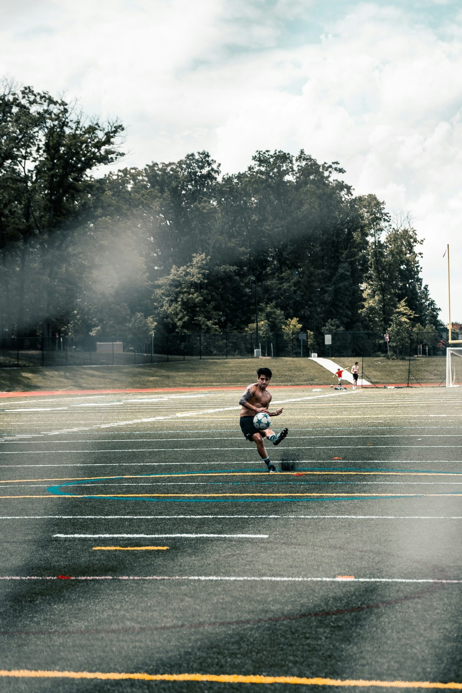 man in red shirt and black shorts riding on black skateboard on gray concrete road during